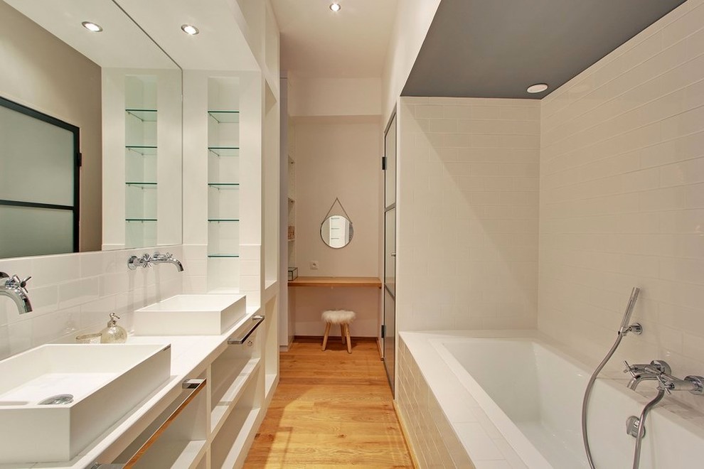 Идея дизайна: большая, узкая и длинная главная ванная комната в современном стиле с открытыми фасадами, накладной ванной, плиткой кабанчик, белыми стенами, настольной раковиной, белой плиткой и паркетным полом среднего тона