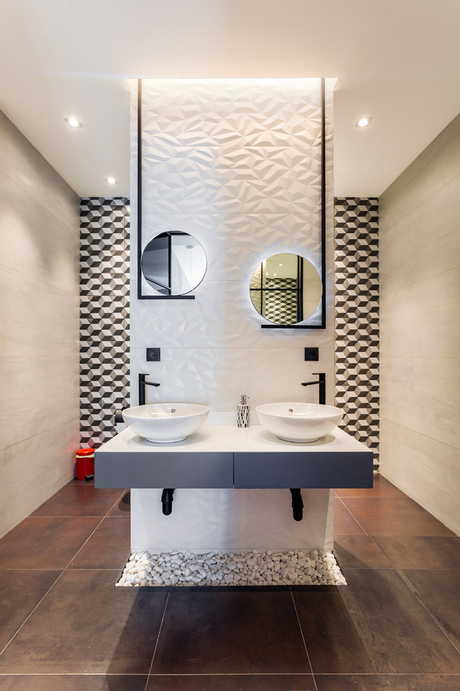 Example of a large trendy master white tile and ceramic tile brown floor bathroom design in Other with gray cabinets, white walls, solid surface countertops, white countertops, flat-panel cabinets and a vessel sink
