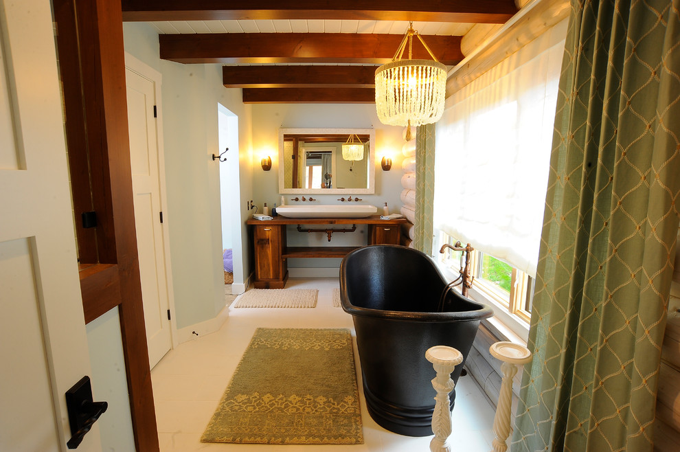 Immagine di una stanza da bagno padronale stile rurale di medie dimensioni con consolle stile comò, ante in legno scuro, pareti grigie, pavimento con piastrelle in ceramica, lavabo integrato, top in legno, pavimento bianco e top marrone