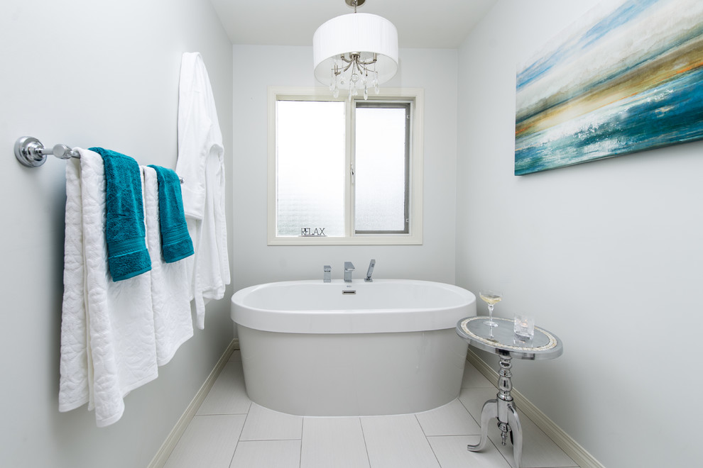 Design ideas for a medium sized contemporary ensuite bathroom in Vancouver with a submerged sink, shaker cabinets, black cabinets, glass worktops, a freestanding bath, a one-piece toilet, white tiles, porcelain tiles, blue walls and ceramic flooring.
