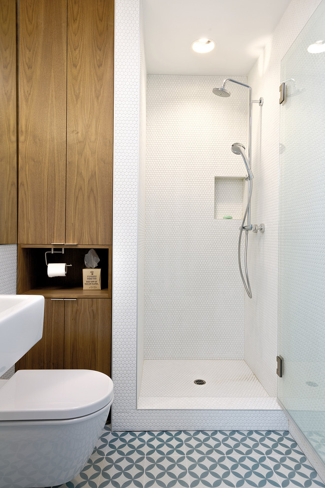 Aménagement d'une salle de bain scandinave en bois brun avec un placard à porte plane, WC suspendus, un carrelage blanc, mosaïque, un mur blanc et sol en béton ciré.