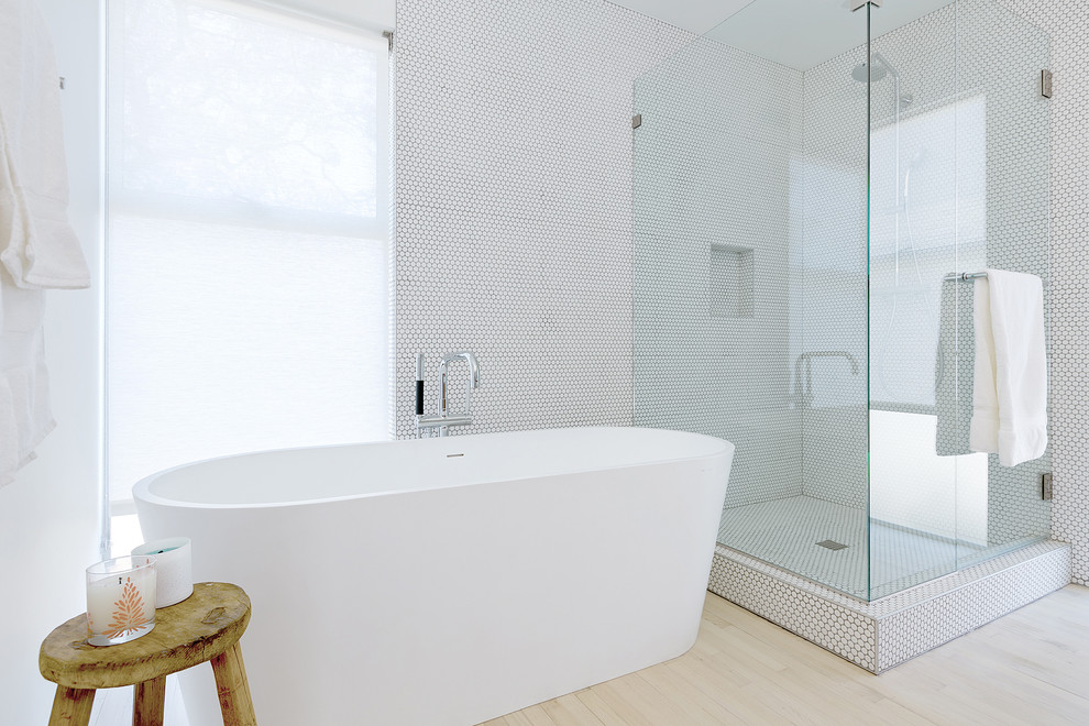 Foto di una stanza da bagno padronale scandinava con vasca freestanding, doccia ad angolo, piastrelle bianche, piastrelle a mosaico, pareti bianche e parquet chiaro
