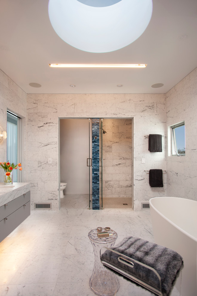 Idee per una stanza da bagno minimal di medie dimensioni con lavabo sottopiano, ante lisce, ante grigie, vasca freestanding, piastrelle bianche e doccia alcova