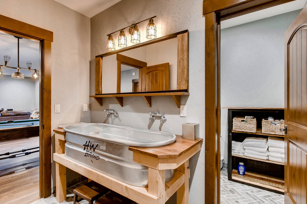 Design ideas for a medium sized rustic family bathroom in Denver with freestanding cabinets, green tiles, grey walls, ceramic flooring, a trough sink, wooden worktops, grey floors and brown worktops.