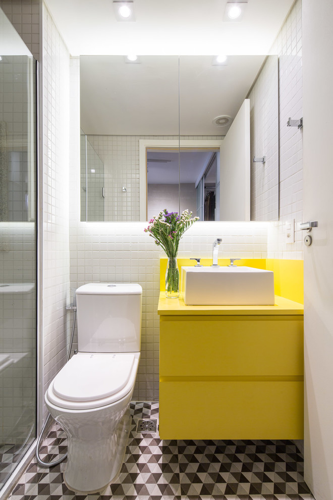 Mittelgroßes Modernes Duschbad mit Aufsatzwaschbecken, gelben Schränken, Eckdusche, weißen Fliesen, Zementfliesen, weißer Wandfarbe, Porzellan-Bodenfliesen und flächenbündigen Schrankfronten