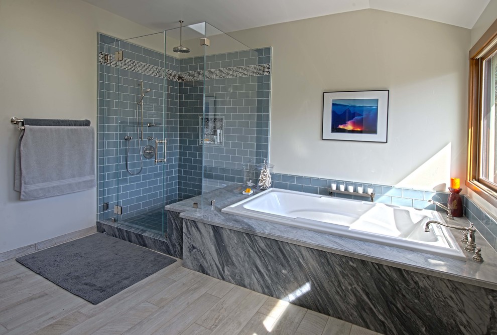 На фото: большая главная ванная комната в стиле кантри с фасадами в стиле шейкер, темными деревянными фасадами, угловым душем, унитазом-моноблоком, синей плиткой, стеклянной плиткой, белыми стенами, полом из травертина, врезной раковиной, столешницей из гранита, накладной ванной, серым полом, душем с распашными дверями и синей столешницей с