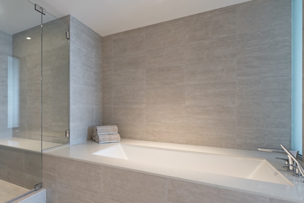 Свежая идея для дизайна: большая главная ванная комната в стиле модернизм с полновстраиваемой ванной, душем в нише, серой плиткой, керамогранитной плиткой и душем с распашными дверями - отличное фото интерьера