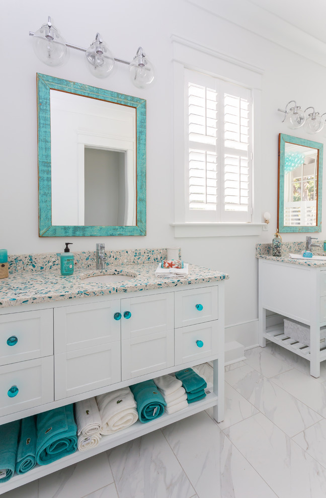 Example of a small beach style master cement tile floor and beige floor freestanding bathtub design in Charleston with furniture-like cabinets, white cabinets, white walls, terrazzo countertops and multicolored countertops