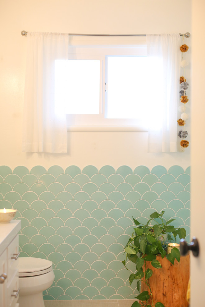 Aménagement d'une salle de bain éclectique de taille moyenne pour enfant avec des portes de placard blanches, un combiné douche/baignoire, un carrelage bleu, des carreaux de céramique et un mur blanc.