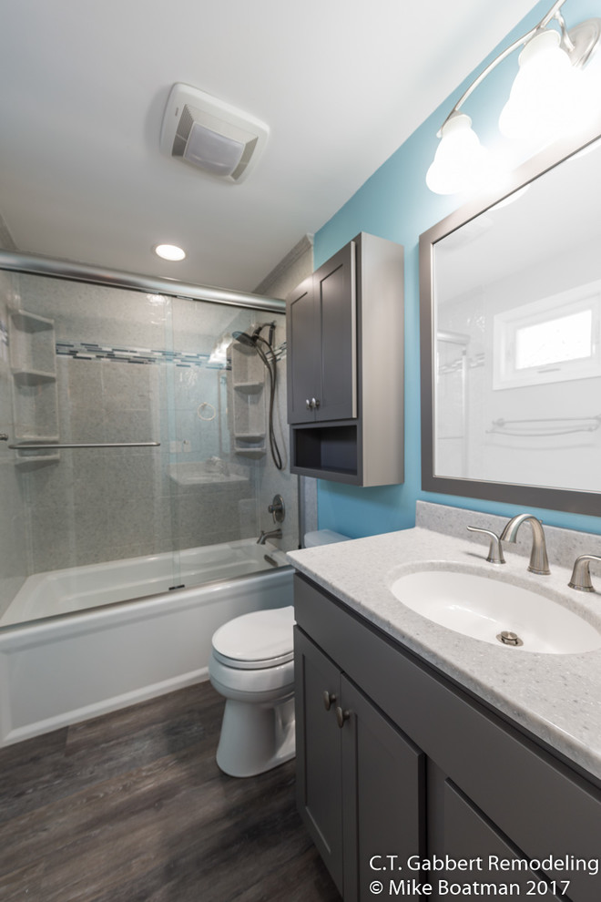 Bathroom - mid-sized contemporary 3/4 vinyl floor and brown floor bathroom idea in Chicago with beaded inset cabinets, gray cabinets, blue walls, an integrated sink and onyx countertops