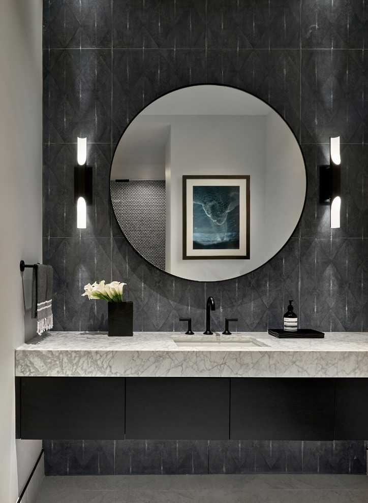 Inspiration for a contemporary bathroom in Chicago with flat-panel cabinets, black cabinets, black tiles, black walls, a submerged sink, grey floors and white worktops.