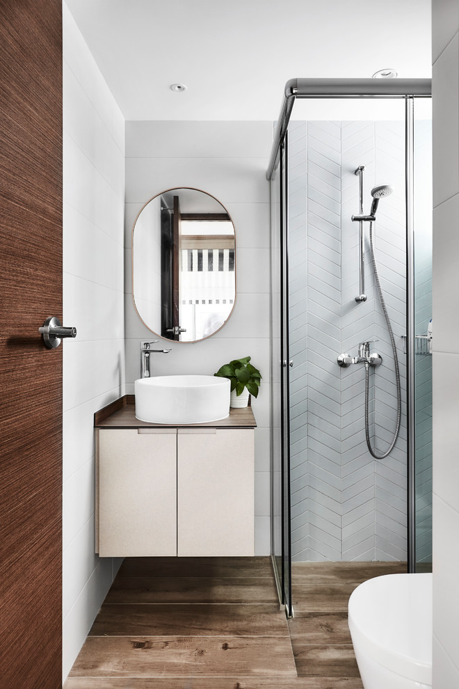 Contemporary shower room bathroom in Singapore with flat-panel cabinets, white cabinets, a built-in shower, white tiles, white walls, a vessel sink, brown floors, a sliding door and brown worktops.