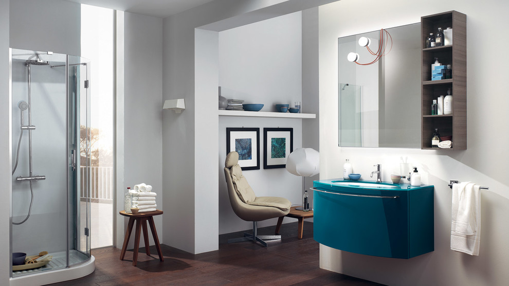 Foto på ett stort funkis badrum, med ett undermonterad handfat, luckor med upphöjd panel, blå skåp, bänkskiva i glas, en dusch i en alkov, vita väggar och mörkt trägolv