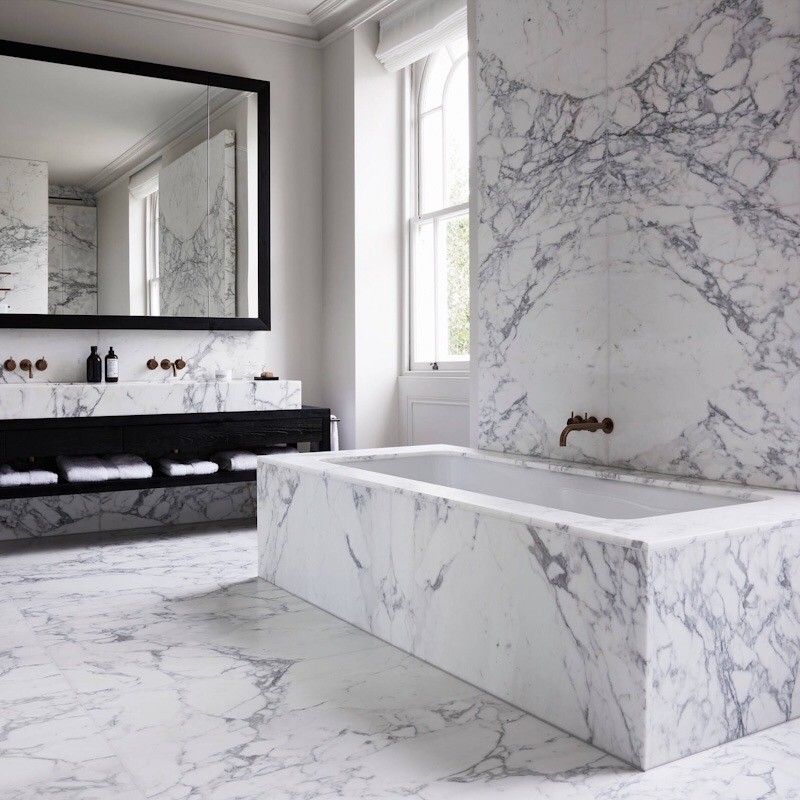 Inredning av ett modernt stort vit vitt badrum, med luckor med upphöjd panel, vita skåp, ett platsbyggt badkar, våtrum, en toalettstol med hel cisternkåpa, grå kakel, marmorkakel, vita väggar, marmorgolv, ett nedsänkt handfat, marmorbänkskiva, vitt golv och dusch med gångjärnsdörr