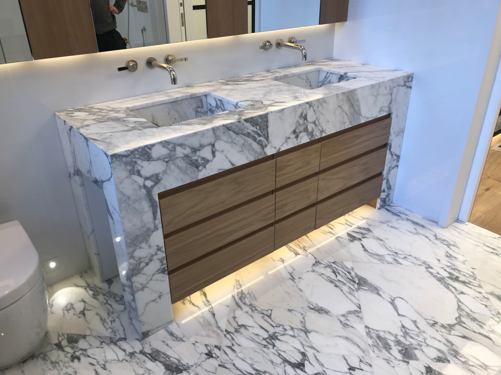 This is an example of a large bohemian ensuite bathroom in London with freestanding cabinets, white cabinets, marble flooring, an integrated sink, marble worktops and white worktops.