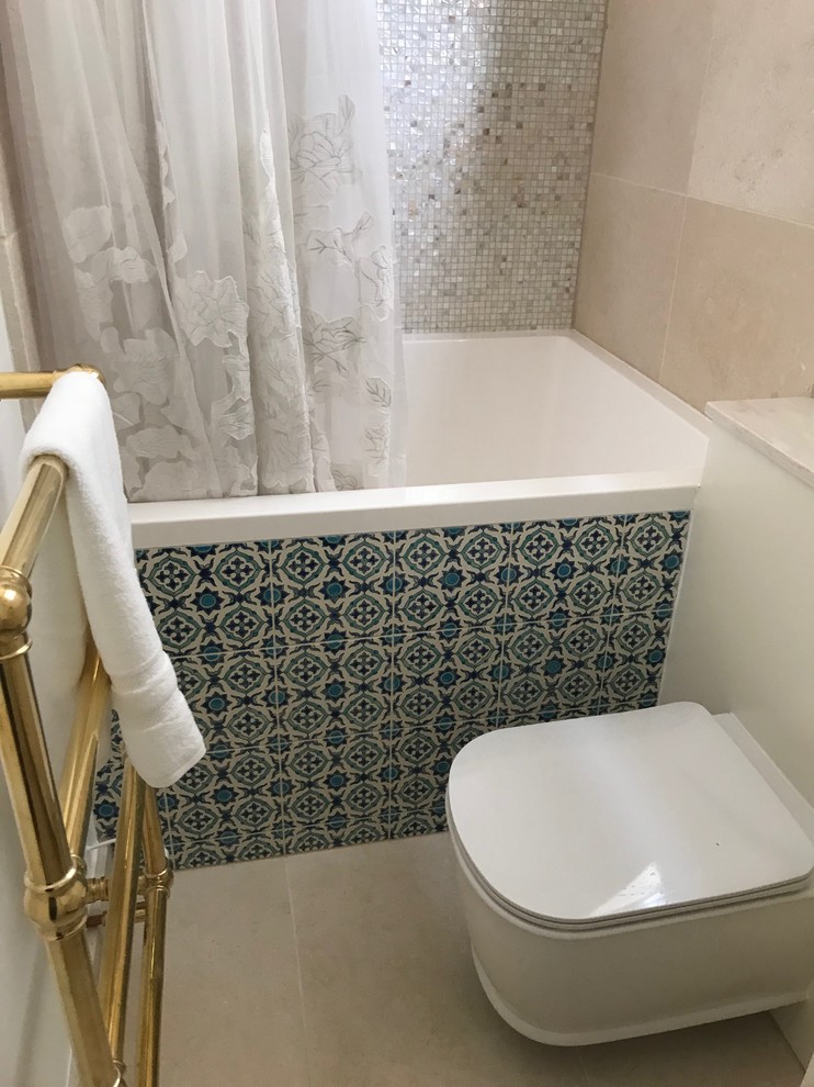 Inspiration for a small mediterranean family bathroom in London with raised-panel cabinets, beige cabinets, a japanese bath, a shower/bath combination, a wall mounted toilet, beige tiles, ceramic tiles, beige walls, ceramic flooring, an integrated sink, solid surface worktops, beige floors and a shower curtain.