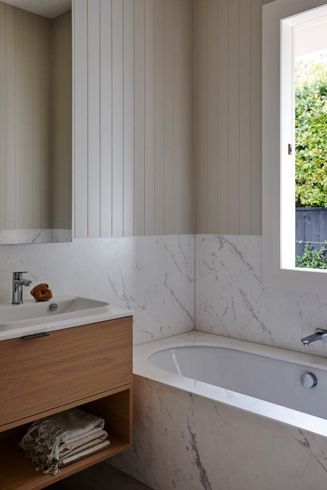 Inspiration för små moderna vitt en-suite badrum, med ett undermonterat badkar, vit kakel, marmorkakel, grå väggar, bänkskiva i akrylsten, släta luckor, skåp i mellenmörkt trä och ett nedsänkt handfat