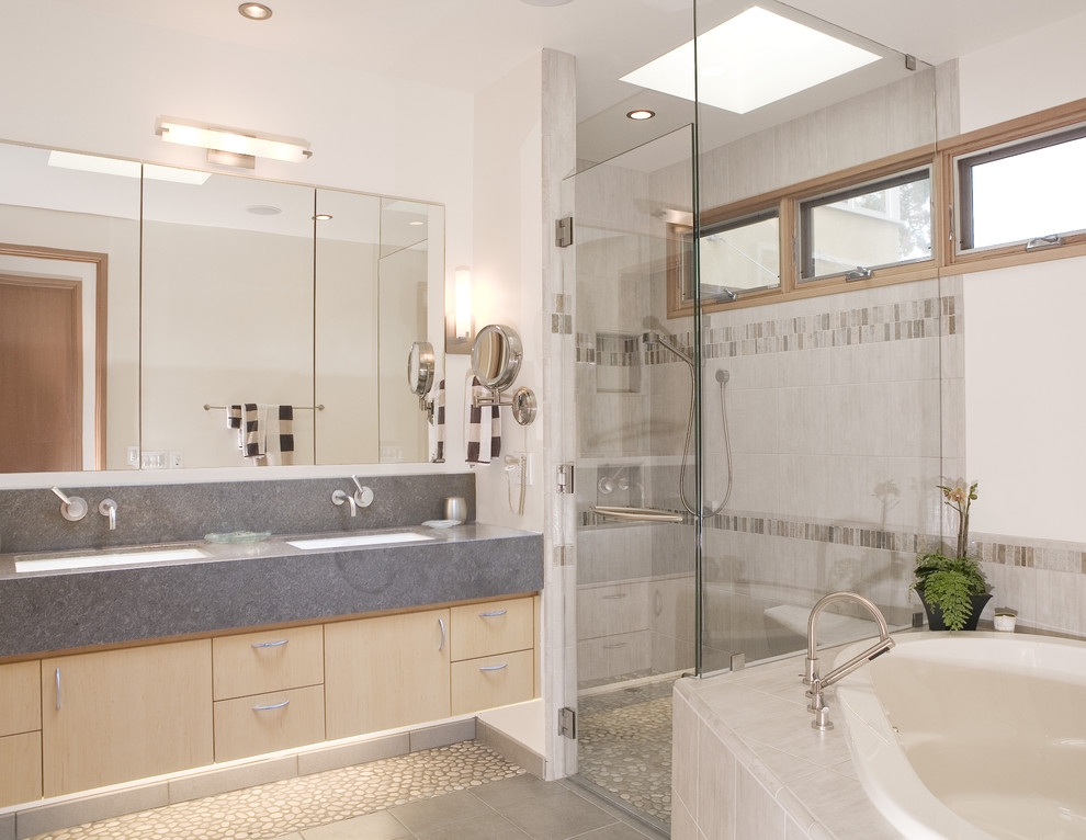 Réalisation d'une salle de bain design en bois clair de taille moyenne avec un lavabo encastré, un placard à porte plane, une baignoire posée, une douche d'angle, un carrelage beige, un sol en galet, une fenêtre, un mur blanc, un sol multicolore, aucune cabine et meuble double vasque.
