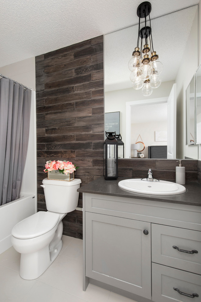 Design ideas for a medium sized traditional bathroom in Calgary with shaker cabinets, grey cabinets, an alcove bath, a shower/bath combination, brown tiles, multi-coloured walls, a built-in sink, quartz worktops, white floors, a shower curtain and grey worktops.
