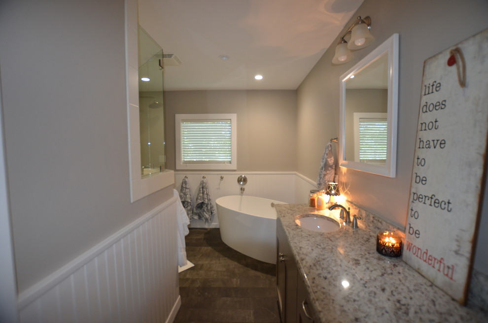 Mid-sized trendy master gray tile and ceramic tile ceramic tile bathroom photo in Austin with an undermount sink, recessed-panel cabinets, gray cabinets, granite countertops, a one-piece toilet and gray walls
