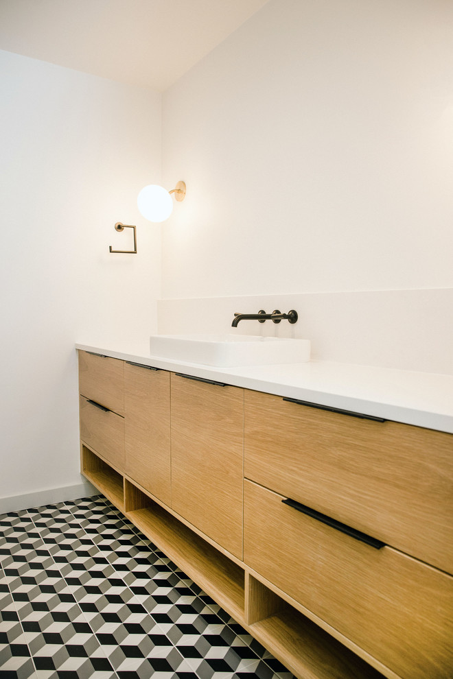 Пример оригинального дизайна: ванная комната среднего размера с плоскими фасадами, светлыми деревянными фасадами, двойным душем, белой плиткой, керамической плиткой, белыми стенами, полом из керамической плитки, накладной раковиной, столешницей из искусственного кварца, черным полом, душем с распашными дверями и белой столешницей