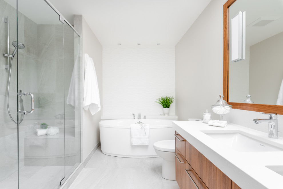 Inspiration för ett funkis vit vitt badrum, med släta luckor, skåp i mellenmörkt trä, ett fristående badkar, grå väggar, ett undermonterad handfat och grått golv