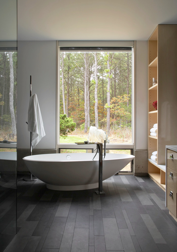 Minimalist master freestanding bathtub photo in New York with flat-panel cabinets, light wood cabinets and white walls