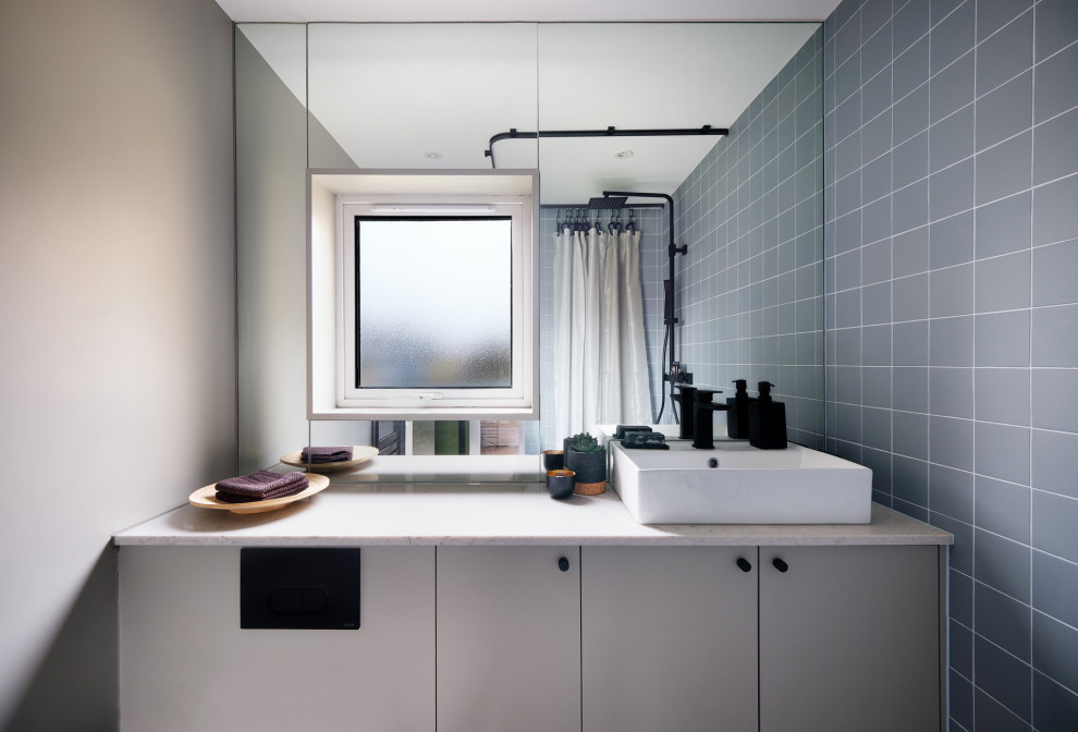 Design ideas for a medium sized contemporary bathroom in London with flat-panel cabinets, grey cabinets, a wall mounted toilet, porcelain tiles, grey walls, porcelain flooring, quartz worktops, grey floors, a shower curtain, grey worktops, a wall niche, a single sink, a built in vanity unit, grey tiles and a vessel sink.