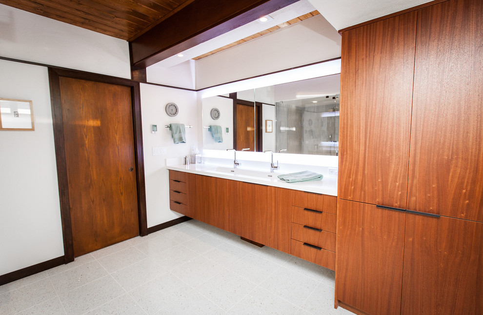 ソルトレイクシティにあるミッドセンチュリースタイルのおしゃれなマスターバスルーム (フラットパネル扉のキャビネット、中間色木目調キャビネット、白い壁、テラゾーの床、珪岩の洗面台) の写真
