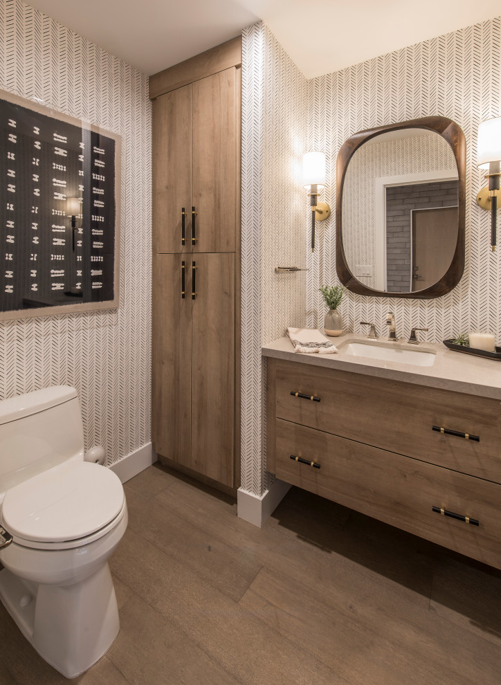 Modernes Badezimmer mit flächenbündigen Schrankfronten, hellbraunen Holzschränken, grauer Wandfarbe, braunem Holzboden, Unterbauwaschbecken, braunem Boden und grauer Waschtischplatte in Phoenix