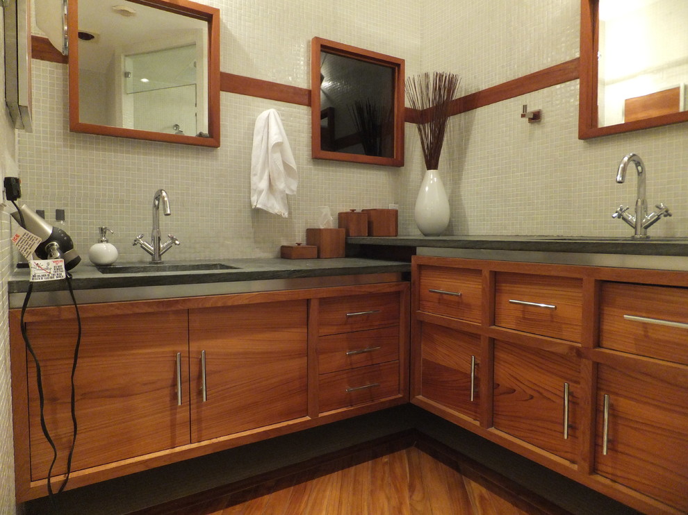 ロサンゼルスにある高級な中くらいなモダンスタイルのおしゃれな浴室 (アンダーカウンター洗面器、アルコーブ型浴槽、分離型トイレ、オープン型シャワー、家具調キャビネット、中間色木目調キャビネット、ライムストーンの洗面台、白いタイル、白い壁、淡色無垢フローリング) の写真