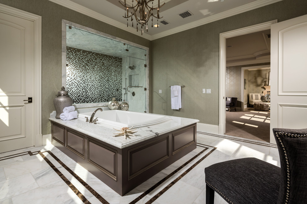 Inspiration for a mid-sized transitional master white tile and stone tile marble floor drop-in bathtub remodel in Los Angeles with raised-panel cabinets, brown cabinets, marble countertops and beige walls