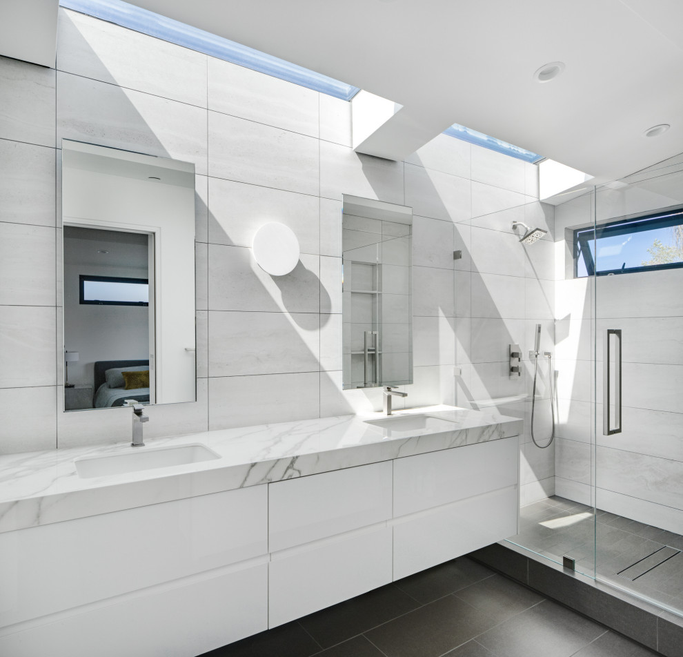 Идея дизайна: ванная комната в современном стиле с плоскими фасадами, белыми фасадами, белой плиткой, врезной раковиной, серым полом, белой столешницей, тумбой под две раковины и подвесной тумбой