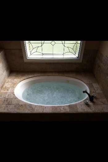 Inspiration för mellanstora medelhavsstil en-suite badrum, med ett platsbyggt badkar, en dusch i en alkov, porslinskakel och travertin golv