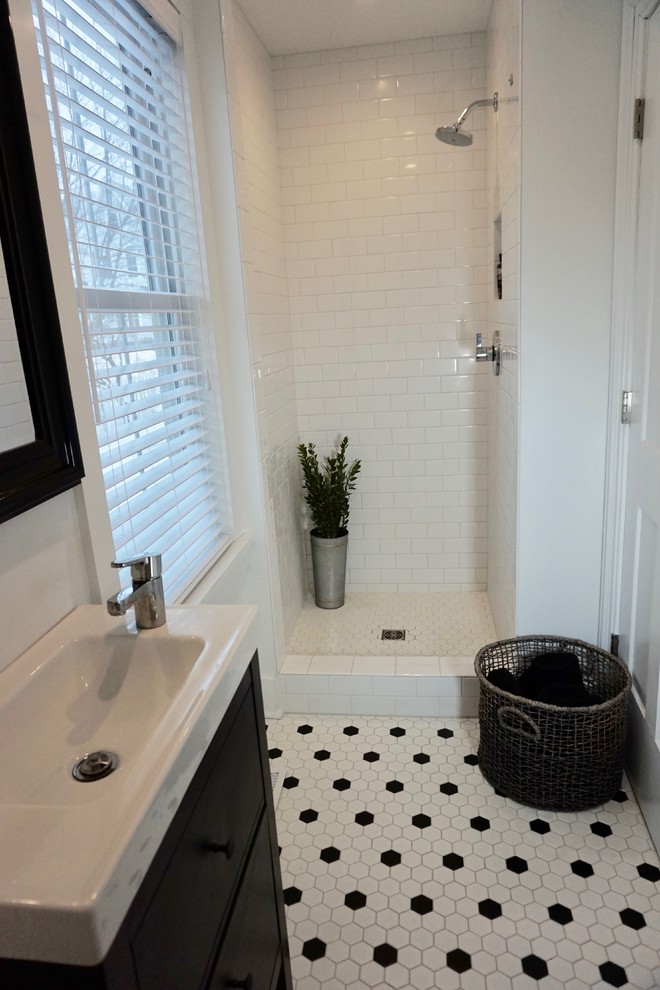 Kleines Klassisches Duschbad mit Schrankfronten im Shaker-Stil, schwarzen Schränken, Duschnische, Toilette mit Aufsatzspülkasten, weißen Fliesen, Keramikfliesen, weißer Wandfarbe, Keramikboden, integriertem Waschbecken, weißem Boden und Duschvorhang-Duschabtrennung in Charleston