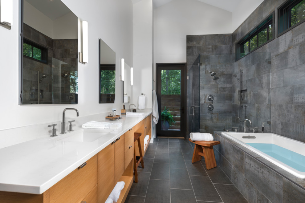 На фото: главная ванная комната в современном стиле с плоскими фасадами, светлыми деревянными фасадами, угловой ванной, угловым душем, серой плиткой, врезной раковиной, серым полом и душем с распашными дверями