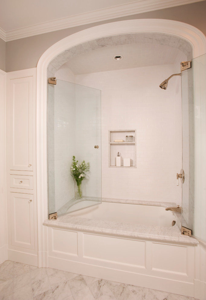 Ejemplo de cuarto de baño principal tradicional pequeño con puertas de armario blancas, bañera empotrada, combinación de ducha y bañera, baldosas y/o azulejos de cerámica, paredes grises, suelo de mármol y armarios con paneles empotrados
