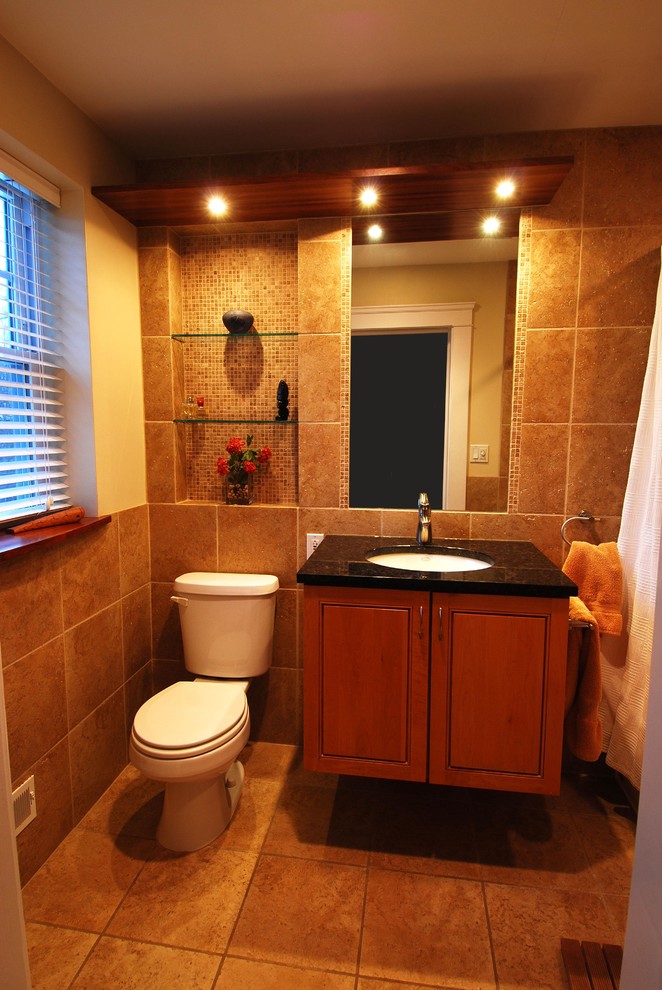 Inspiration för ett mellanstort funkis badrum, med ett undermonterad handfat, skåp i shakerstil, skåp i ljust trä, granitbänkskiva, ett badkar i en alkov, en dusch/badkar-kombination, en toalettstol med separat cisternkåpa, beige kakel, porslinskakel, gula väggar och klinkergolv i porslin