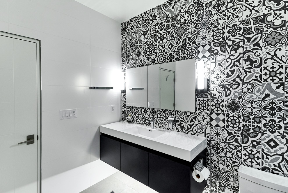 Inredning av ett modernt mellanstort vit vitt badrum med dusch, med släta luckor, svarta skåp, svart och vit kakel, cementkakel, flerfärgade väggar, klinkergolv i porslin, ett integrerad handfat, bänkskiva i kvarts och vitt golv