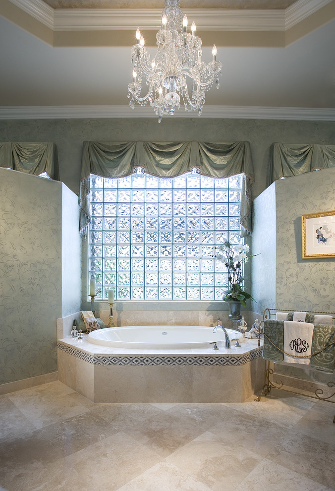 На фото: ванная комната в классическом стиле с накладной ванной и бежевой плиткой с