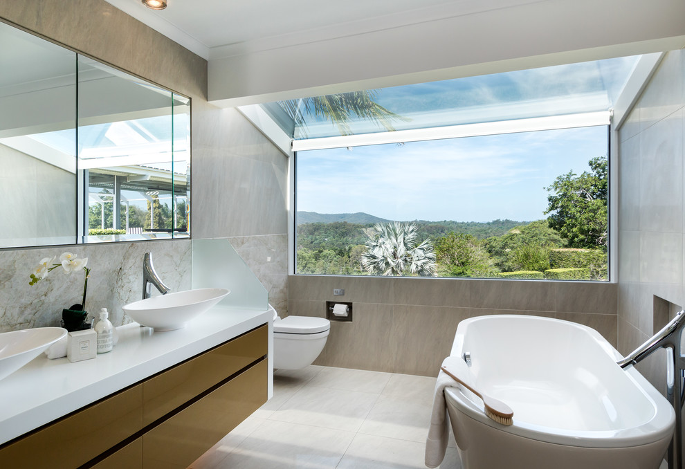 Mittelgroßes Modernes Badezimmer mit flächenbündigen Schrankfronten, freistehender Badewanne, grauen Fliesen, Aufsatzwaschbecken und grauem Boden in Brisbane
