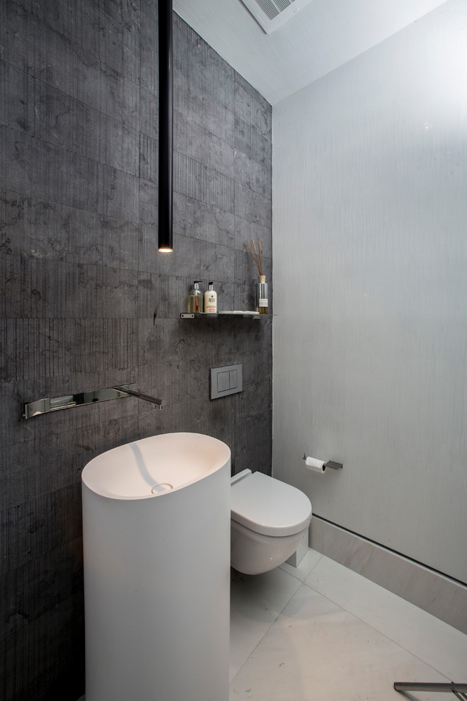 Trendy gray tile powder room photo in Miami with a wall-mount toilet and gray walls