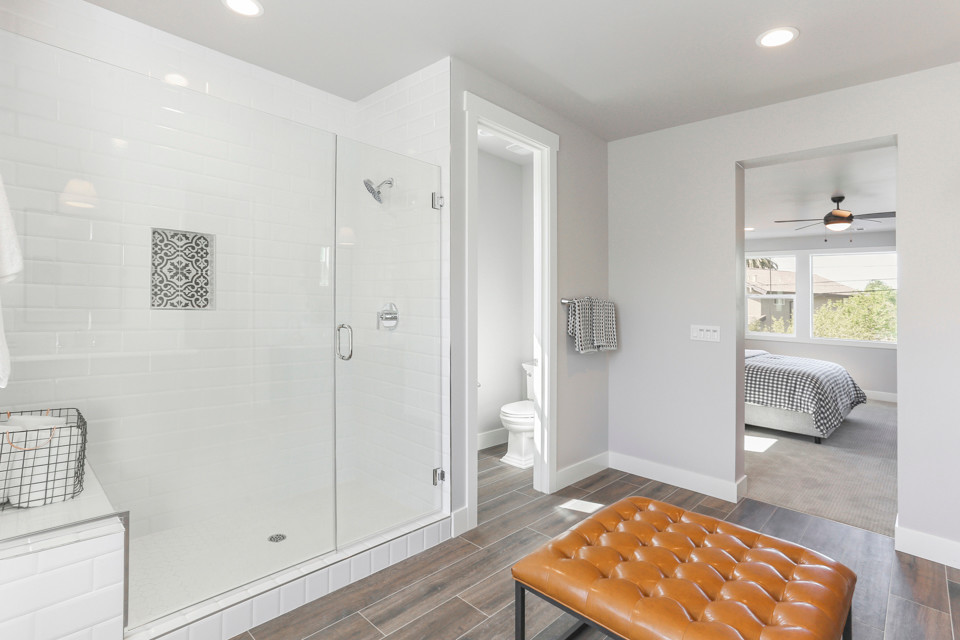 Mid-sized farmhouse master gray tile and ceramic tile porcelain tile and beige floor bathroom photo in Sacramento with furniture-like cabinets, gray cabinets, a one-piece toilet, gray walls, an undermount sink, quartz countertops, a hinged shower door and white countertops