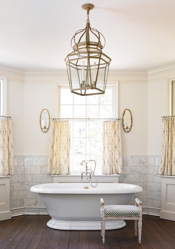 На фото: ванная комната в классическом стиле с отдельно стоящей ванной и белой плиткой