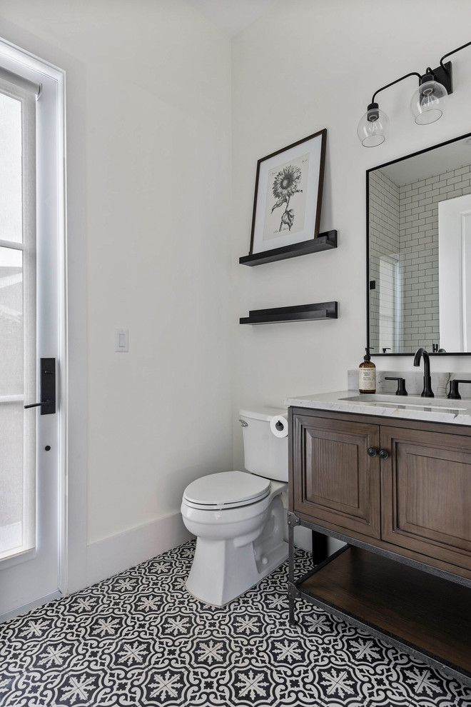 Exempel på ett stort klassiskt grå grått badrum med dusch, med skåp i mörkt trä, en toalettstol med separat cisternkåpa, ett konsol handfat, flerfärgat golv, cementgolv och marmorbänkskiva
