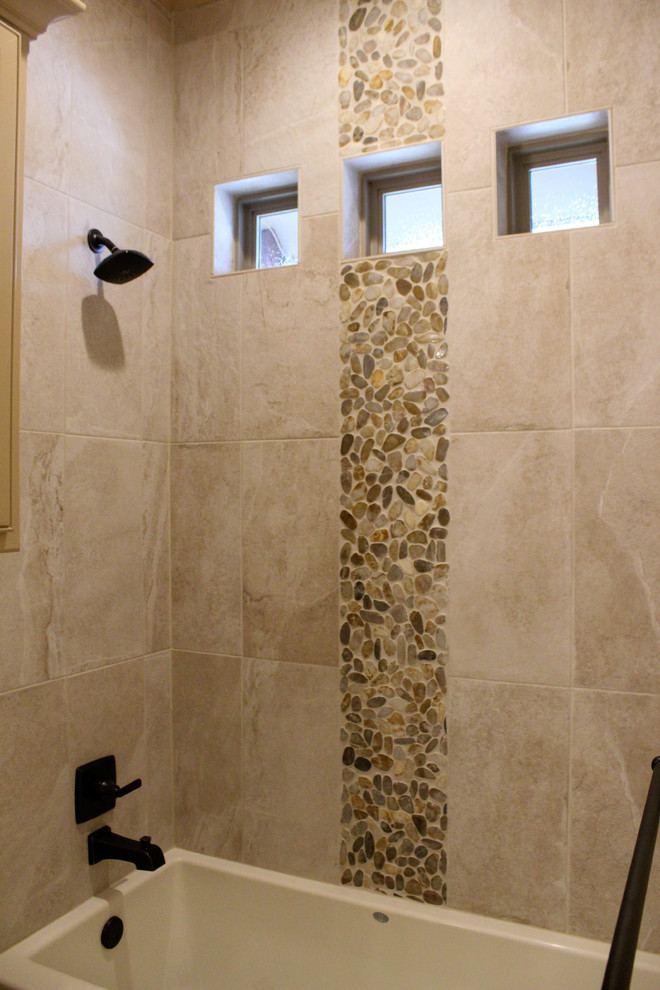 Bild på ett mellanstort vintage badrum för barn, med ett badkar i en alkov, våtrum, en toalettstol med separat cisternkåpa, beige kakel, porslinskakel, beige väggar, klinkergolv i småsten, flerfärgat golv och dusch med duschdraperi