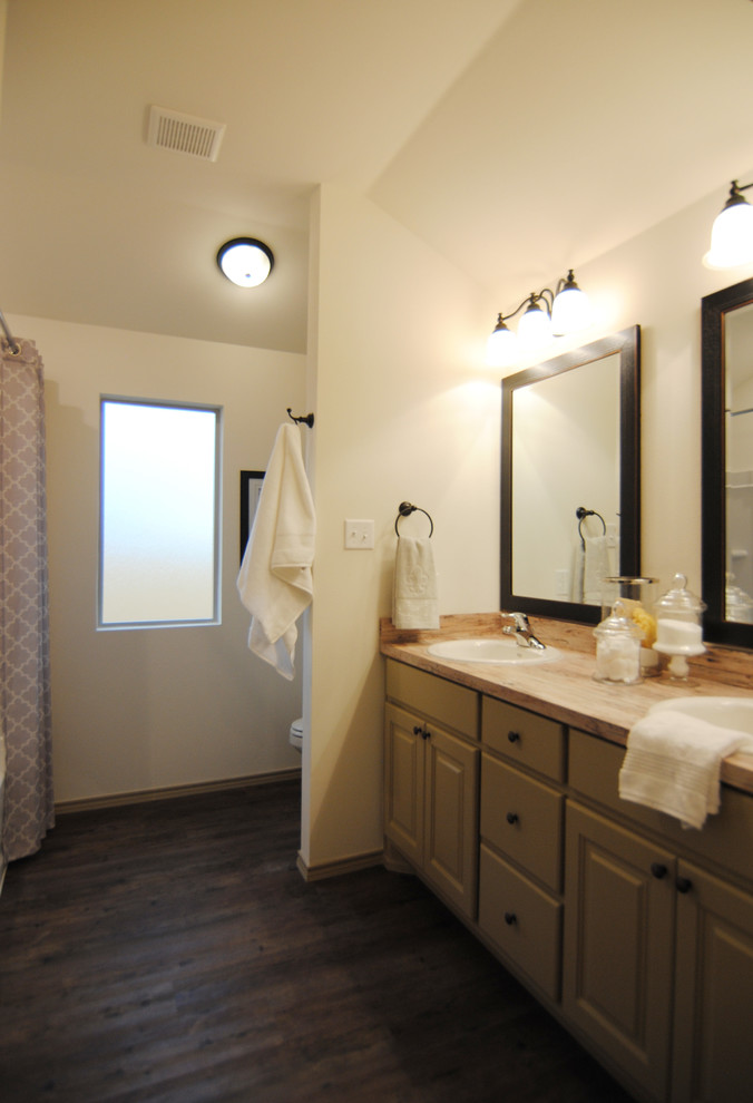 Inspiration for a mid-sized eclectic master vinyl floor bathroom remodel in Austin with recessed-panel cabinets, beige cabinets, a two-piece toilet, white walls, a drop-in sink and laminate countertops