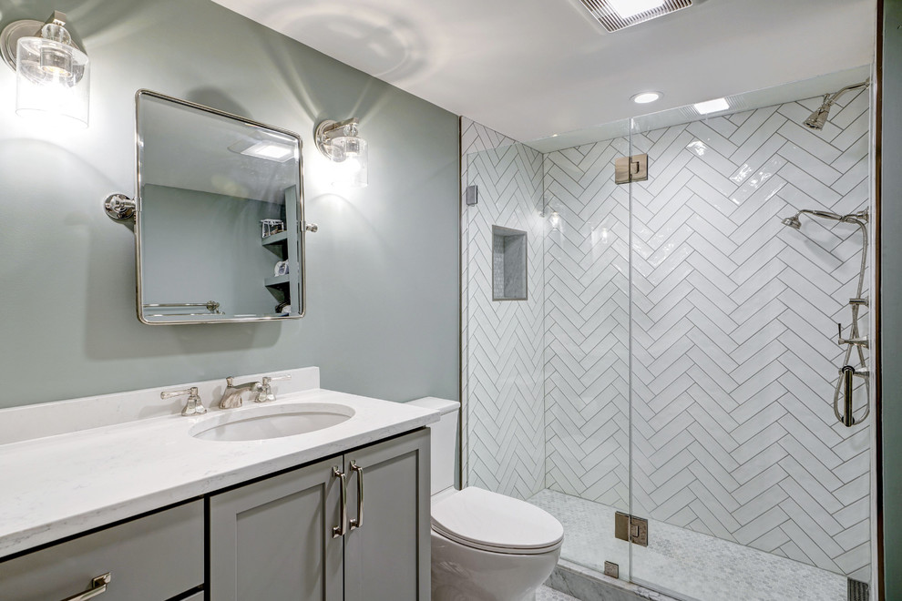 Example of a mid-sized transitional master white tile and ceramic tile marble floor and multicolored floor alcove shower design in DC Metro with shaker cabinets, gray cabinets, a two-piece toilet, green walls, an undermount sink, quartz countertops, a hinged shower door and white countertops