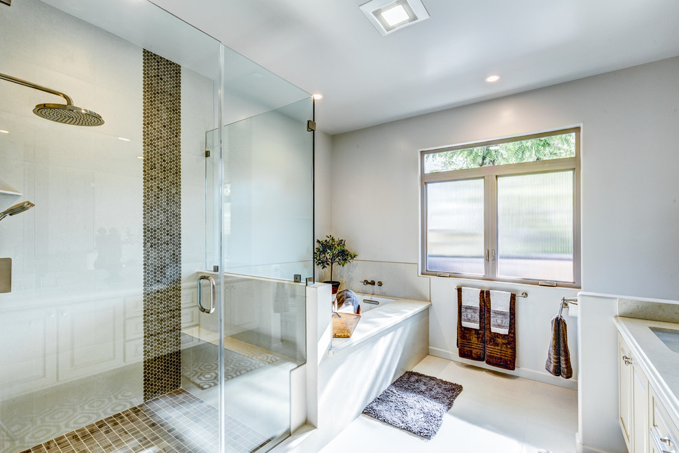 Inspiration for a large transitional master brown tile ceramic tile corner shower remodel in Los Angeles with raised-panel cabinets, beige cabinets, an undermount tub, an undermount sink, quartzite countertops, gray walls and a hinged shower door
