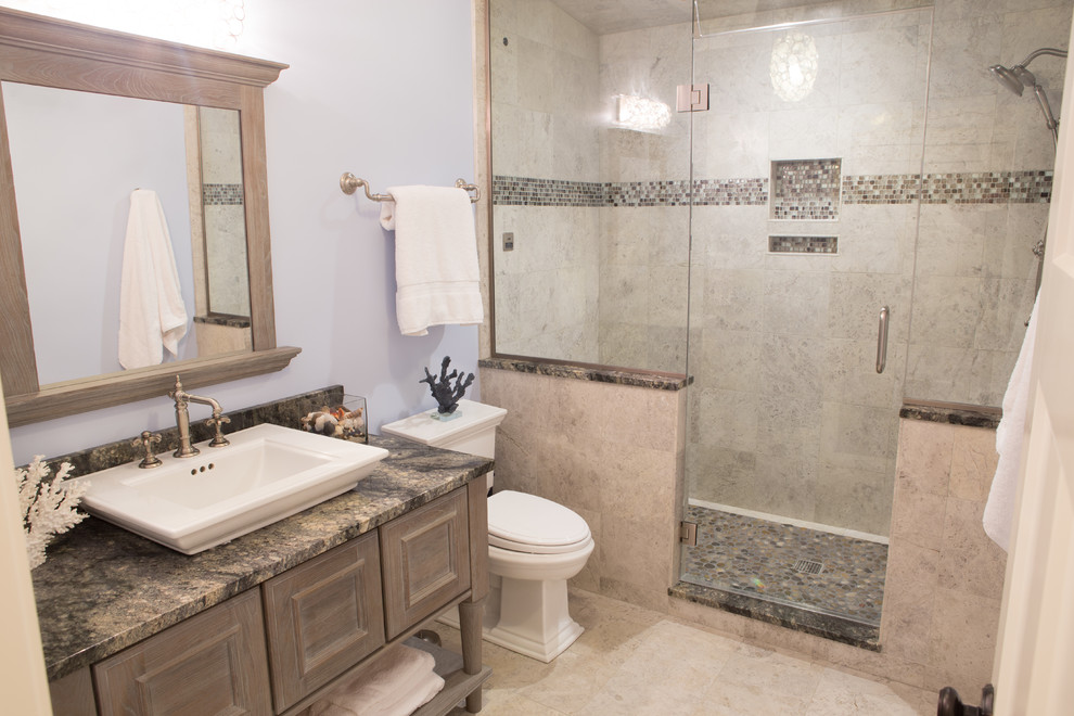 Medium sized traditional shower room bathroom in Chicago with recessed-panel cabinets, grey cabinets, an alcove shower, a one-piece toilet, beige tiles, porcelain tiles, blue walls, porcelain flooring, a vessel sink, granite worktops, beige floors, a hinged door and multi-coloured worktops.